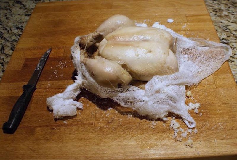 The chicken is removed from the salt and is ready to eat.