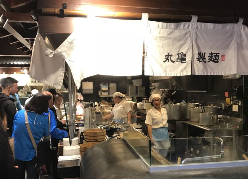 Line cooks preparing dishes of udon noodles at the Marukame Udon restaurant in Waikiki.