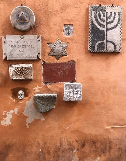 Jewish symbols embedded in a wall in the Jewish Ghetto of Rome.