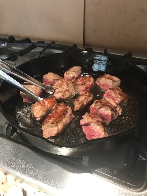 Beef browing in a cast iron skillet