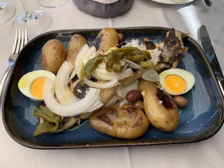 Bacalhau (dried cod fish) with potatoes, onions, olives, peppers and eggs.