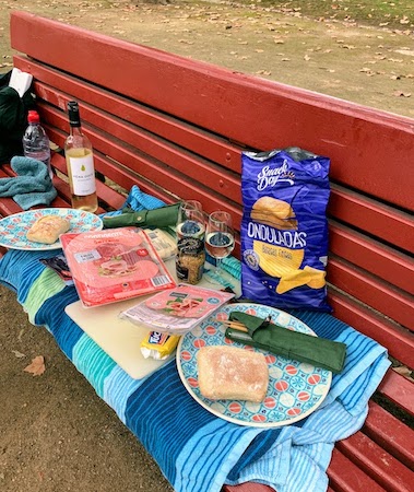 A picnic lunch spread out on a park bench in Porto.