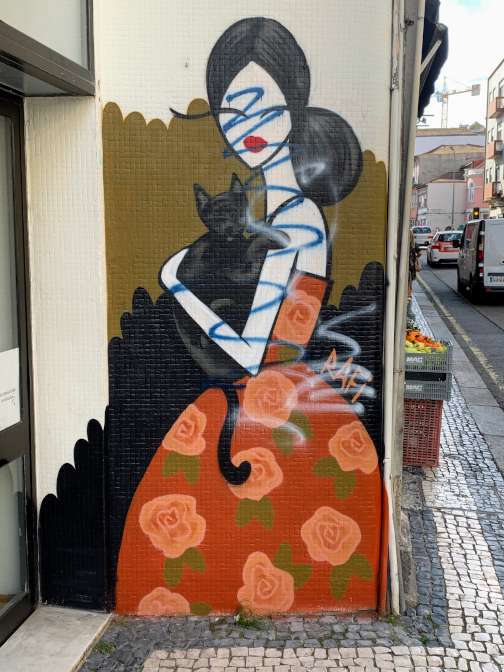 Street art by Rafi in Porto - a woman with a cat