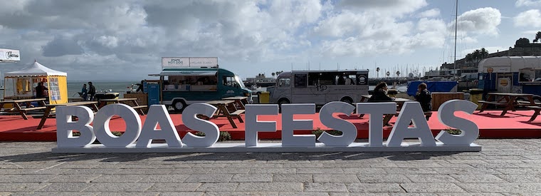 A sign saying "Boas Festas" (Happy Holidays) on the waterfront in Cascais.