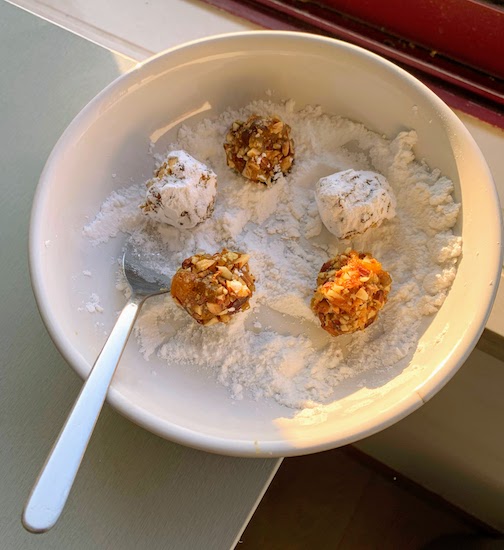 Sugar plums being rolled in powdered sugar.