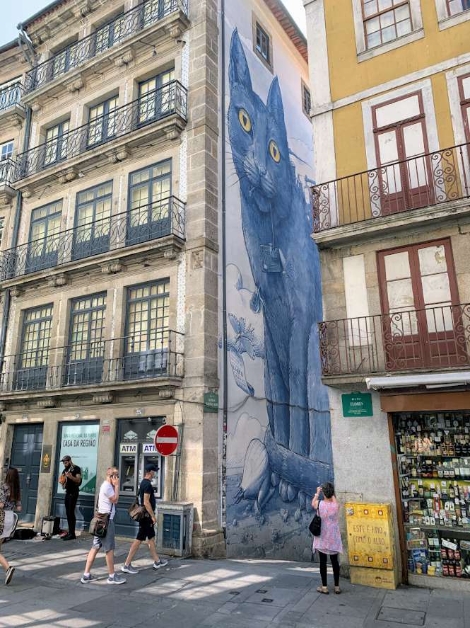 A four story tall mural of a blue cat in Porto.