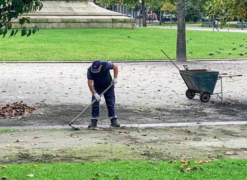 A worker cleaning a path in the Rotunda da Boavista park.