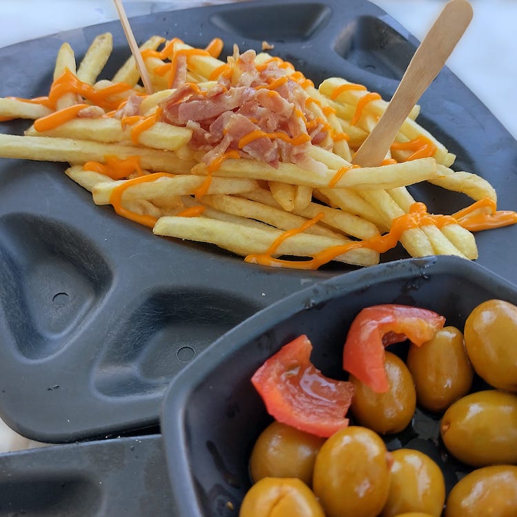 French fries with cheese and bacon at 100 Montaditos in Cascais, Portugal