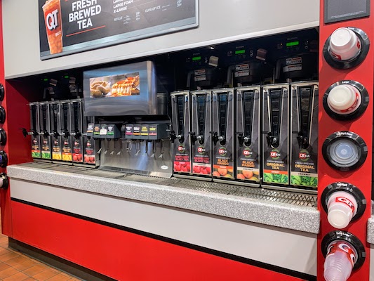 A large drink station in a convenience store with 20 varieties of tea and juice.