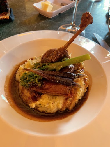 Confit duck leg with mashed truffled potatoes, broccolini, and carrots