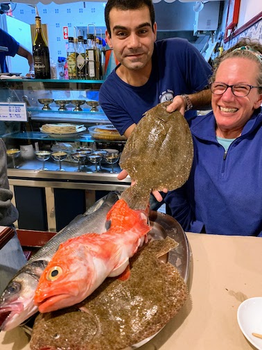 A server showing Mary the selection of fish at Rosa dos Ventos in Nazaré.