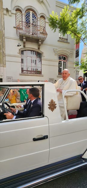 Pope Francis riding in the back of on open car in Lisbon on 3 August 2023.