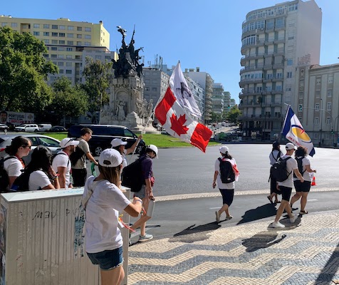 A group of pilgrims carrying a Canadian flag.