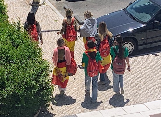 A group of pilgrims in our neighborhood, all wearing colorful clothes.