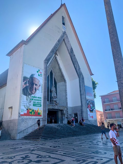 A sign on a local Lisbon church with a picture of Pope Francis and the message "Vemo-nos em Agosto de 2023!" - "See you in August 2023!".