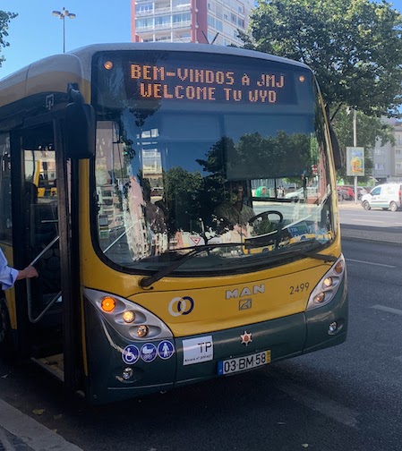 A Lisbon bus with a sign on the front that says "Bem-Vindos á JMJ - Welcome to WYD".