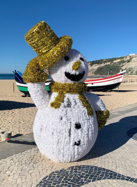 An artificial snowman on the beach at Nazaré, Portugal, December, 2023.