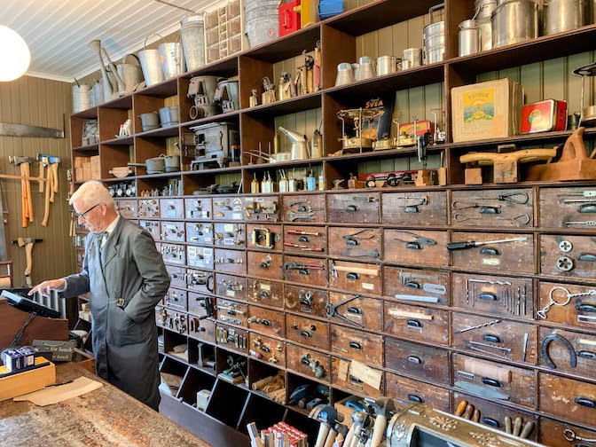 A 1930's era hardware store recreated at Skansen. One wall is lined with wooden shelves and drawers holding a variety of hardware items.