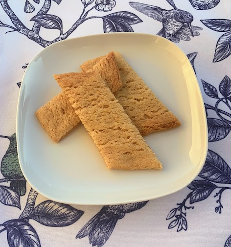 3 Swedish Caramel Cookies on a plate sitting on a placement decorated with drawings of birds.