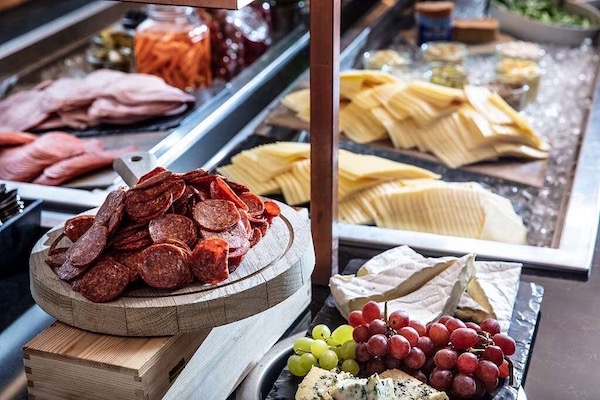 A breakfast buffet selection of meats, cheeses, and fruit at a Swedish hotel.