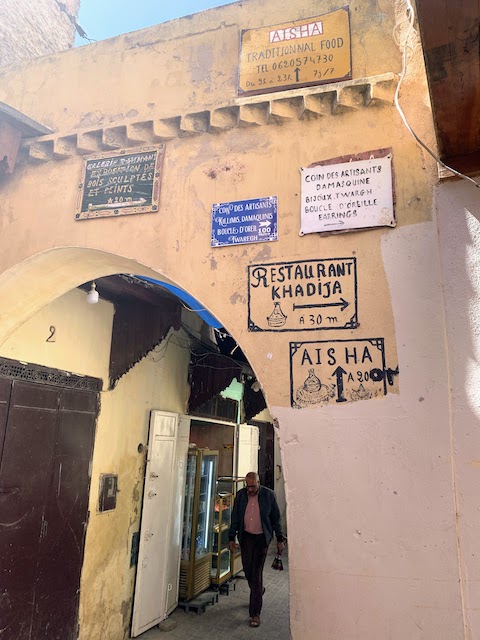 Directional signs on a wall in the Meknes medina.