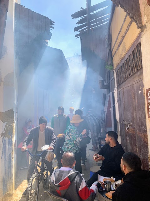 A narrow passageway in the Meknes medina, filled with smoke from cooking fires.