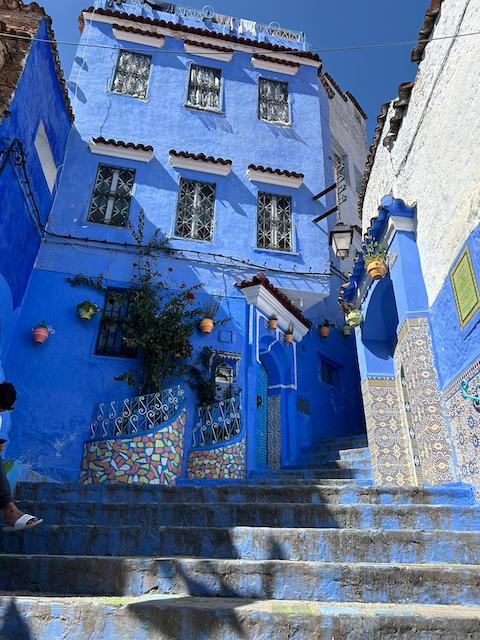 Looking up stairs at a stunning blue house in Chefchaouen.