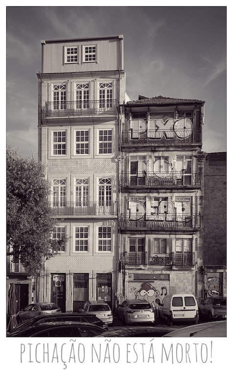 A photo by Jury of a building in Porto with the words "PIXO NOT DEAD" painted on the side. The legend at the bottom translates to "Pichação (Brazilian Portuguese for graffiti) is not dead!"