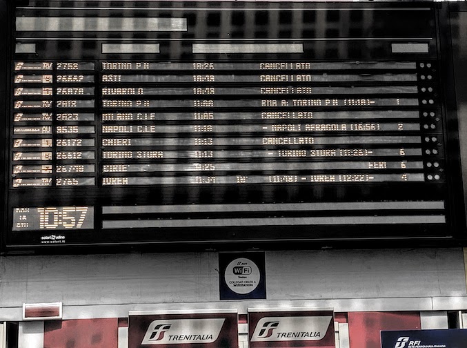 The Departures board at the Torino, Italy rail station showing multiple trains cancelled.