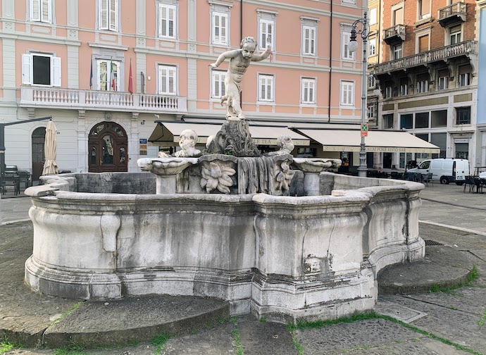 A fountain in the Piazza Ponterosso with a statue of a small naked boy at the top.