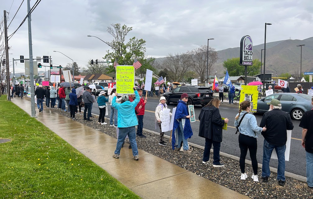 Attendees line Bridge St in Clarkston, WA during a protest rally on April 19, 2025