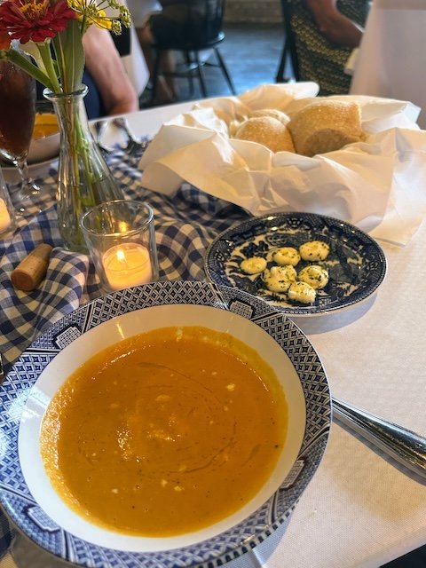 The soup course - roasted pepper and corn soup, sourdough rolls, and small pats of herbed butter.