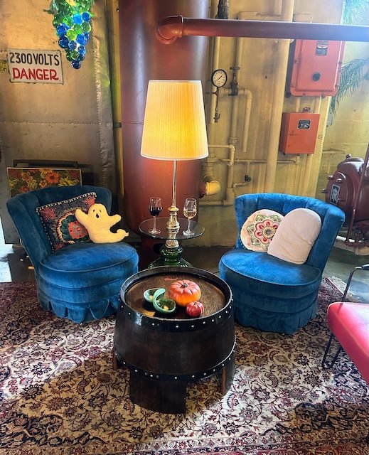 A cozy seating area at the Sunshine Mill Winery with two upholstered chairs, a floor lamp, and a short barrel for a table.